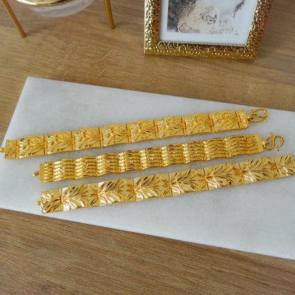 Diverse brede gouden plaat armbanden.