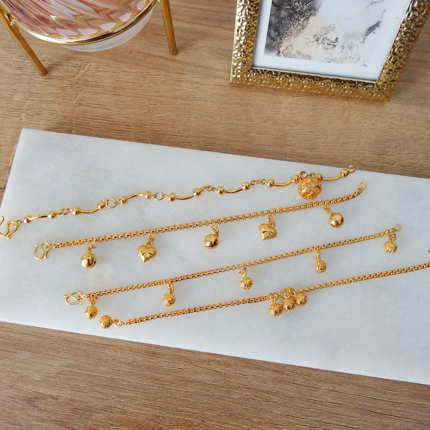 4 verschillende gouden dames armbanden met balletjes en hartjes.