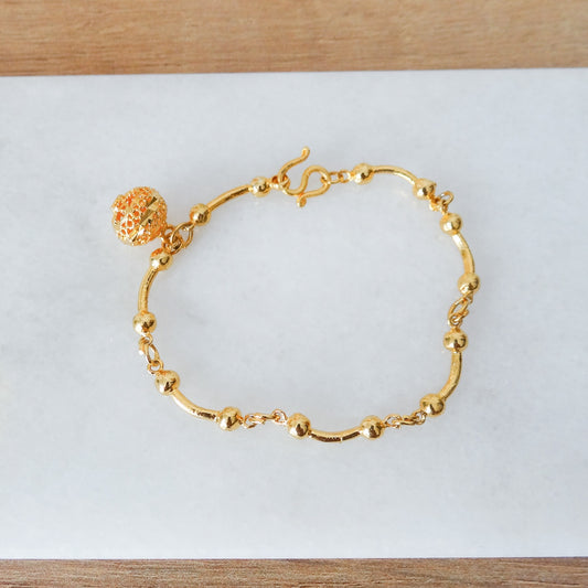 Gouden staafjes armband met een ronde bedel hangertje.