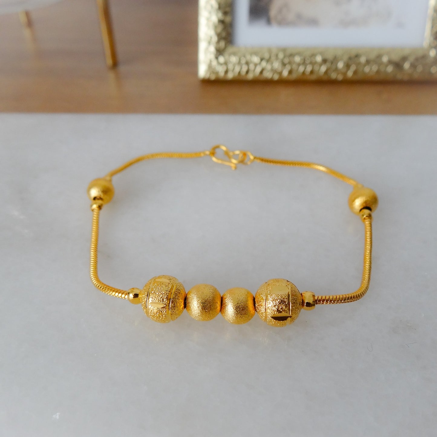 Gouden armband met balletjes.